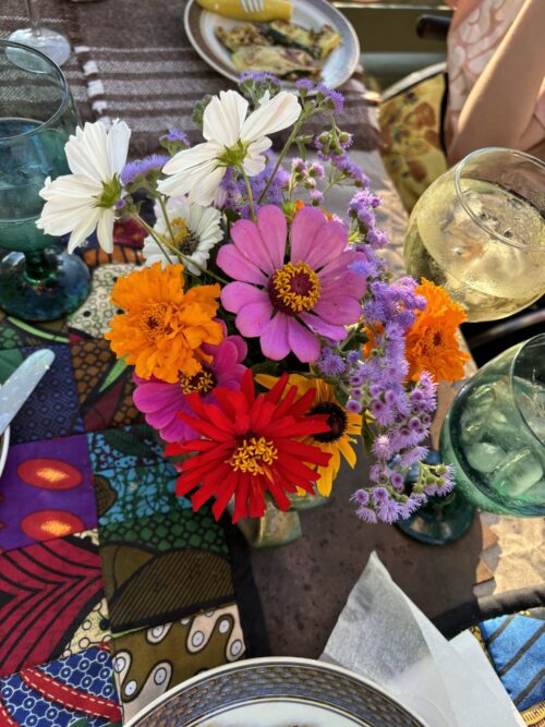 Orange, purple and red wildflowers in a glass